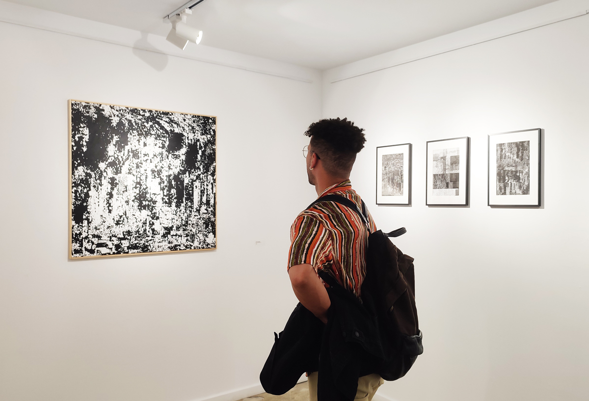man looking an art show at apaixonarte gallery